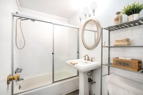 a white bathroom with a shower and a sink at 139-2W Prime west village Furnished 2BR Best value in New York