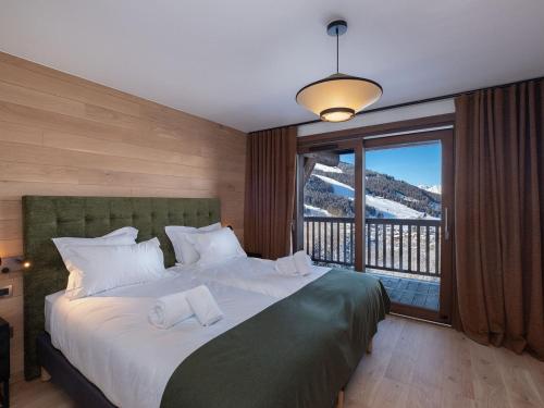 une chambre avec un grand lit avec une grande fenêtre dans l'établissement Luxueux appartement 4 chambres avec balcon, casier à skis, proche des pistes à Courchevel 1650 - FR-1-563-136, à Courchevel