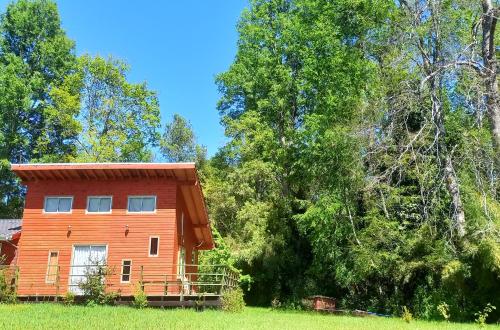a cabin in the middle of a field with trees at Cabaña Rincón Verde in Villarrica