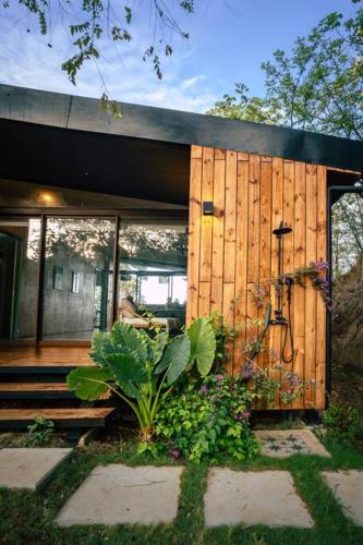a house with a wooden wall and some plants at Casa Samambaia - sea view tropical paradise w' pool in Playa Venao