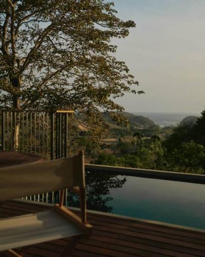 a bench sitting on a deck next to a body of water at Casa Samambaia - sea view tropical paradise w' pool in Playa Venao