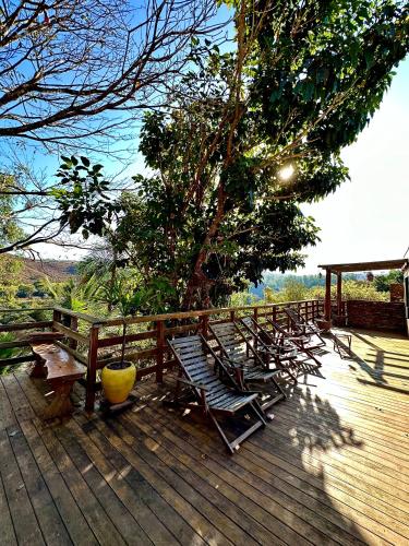 a group of chairs sitting on a wooden deck at Pousada Pato Mergulhão in Vargem Bonita
