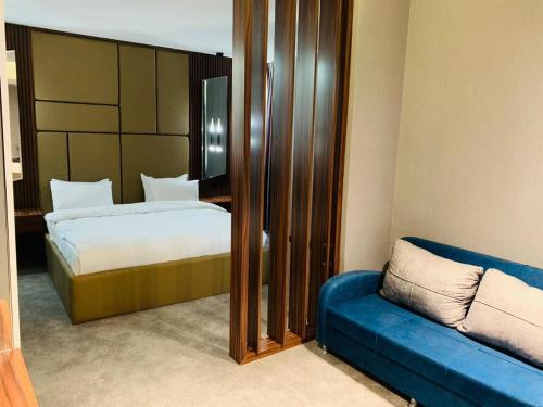 巴格達的住宿－The Capital Heart Hotel，一间卧室配有一张床和一张蓝色的沙发