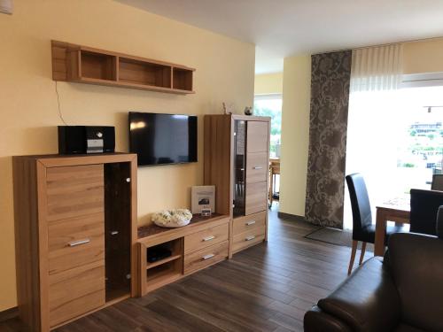 a living room with a entertainment center with a flat screen tv at Traumhafte Ferienwohnung mit direktem Blick auf den Yachthafen in Haren