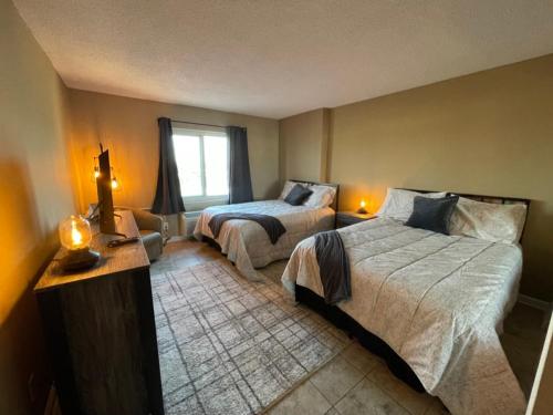 a hotel room with two beds and a window at Playing Hooky at Dolphin Run-Oceanfront Condo-Pool in Virginia Beach