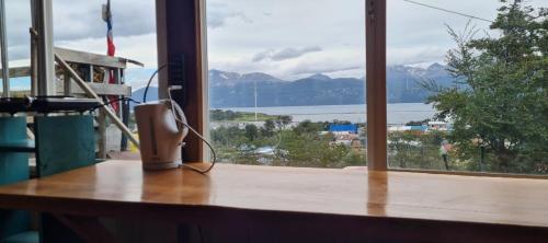 a room with a table with a view of the mountains at Cabaña Puerto Williams in Puerto Williams