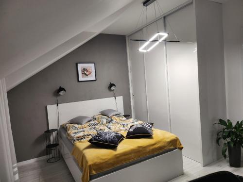 een slaapkamer met een bed met gele lakens en kussens bij Apartament Wiktoria in Łańcut