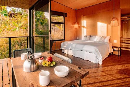 a bedroom with a bed and a table with a tea kettle at Casa Pelícano - Tropical house w' private pool and ocean views in Playa Venao