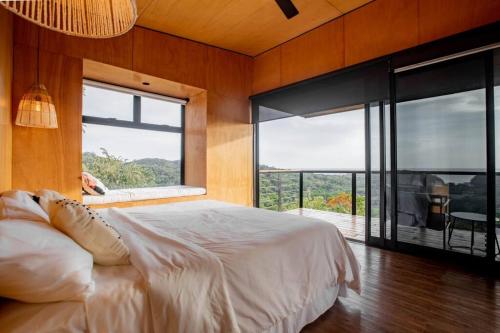 a bedroom with a large bed and a large window at Casa Pelícano - Tropical house w' private pool and ocean views in Playa Venao