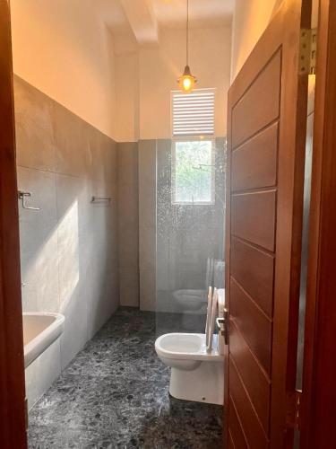 a bathroom with a sink and a toilet and a tub at Hudakala Villa Hanthana in Kandy