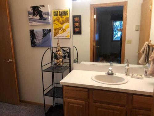 a bathroom with a sink and a mirror at 100 Steps Away Ski in Ski Out Condo in Big Sky