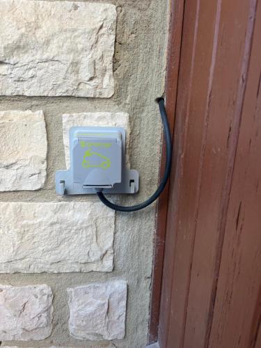 a charger on a brick wall next to a door at Villa Lilause in Hyères