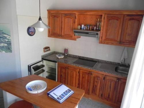 cocina con armarios de madera y mesa de madera en Kleiner Bungalow mit einem Schlafzimmer, en Puerto Naos
