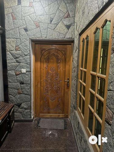 a wooden door in a stone wall with a bench at Edans home stay 