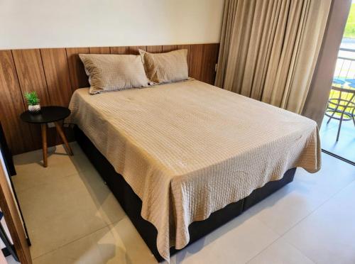 a large bed in a room with a table at Vila do Lago, Praia do Forte in Mata de Sao Joao