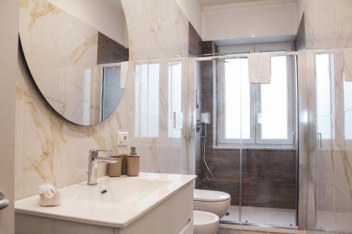 a bathroom with a sink and a toilet and a mirror at B&B Gelso Rosso Pompei in Pompei