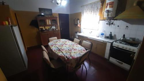 y cocina con mesa, sillas y fogones. en Tolita en Villa del Totoral