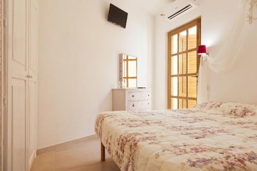 a bedroom with a bed with a dresser and a window at Guest house Acuario in Torre Grande