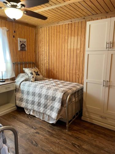 a bedroom with a bed in a room with wooden walls at Bixby Cove Cabin #1 in Porum
