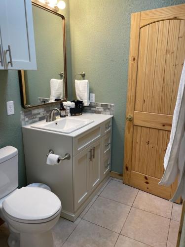 y baño con aseo, lavabo y espejo. en Bixby Cove Cabin #1 en Porum
