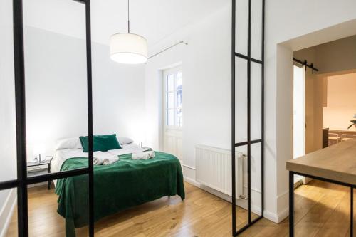 a bedroom with a green bed and a mirror at Zaciszny Zakątek by Rentoom in Toruń