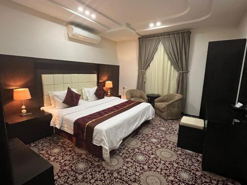 Habitación de hotel con cama y silla en ليالي الين للشقق المخدومة en Buraidah