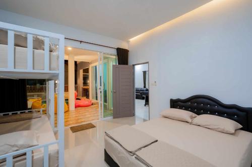 a bedroom with a bed and a bunk bed at พลอยพูลวิลล่า ชะอำ 2 Poolvilla Cha-am 2 in Cha Am