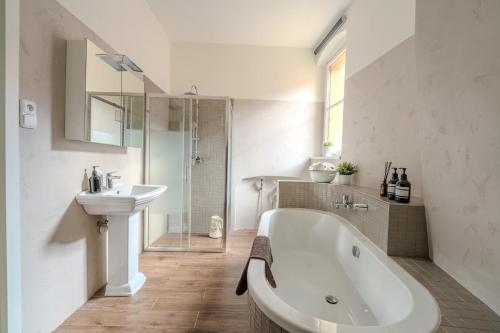a white bathroom with a tub and a sink at Charles Bridge Prague Apartment in Prague