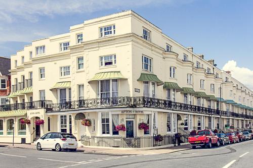 un gran edificio blanco con coches estacionados frente a él en Afton Hotel en Eastbourne