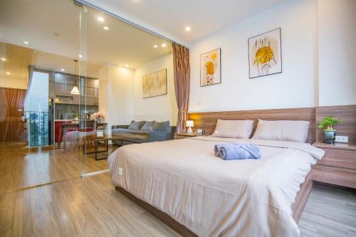 a bedroom with a large bed and a living room at La Passion - Tay Ho Hanoi One Bedroom Apartment! in Hanoi