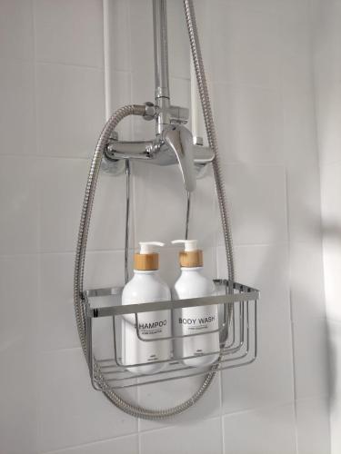 - deux bouteilles sur une étagère en métal dans une salle de bains dans l'établissement Lagny Evasion à Disney, à Lagny-sur-Marne