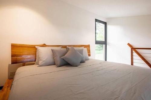 Soul - Tiny Home Venao Cove في بلايا فيناو: غرفة نوم بسرير كبير ومخدات بيضاء