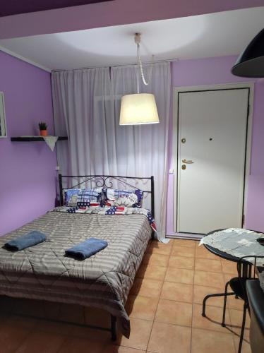 a bedroom with a bed with purple walls and a table at Artemis in Thessaloniki