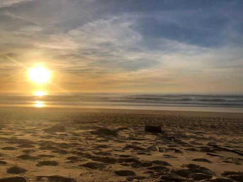 - un coucher de soleil sur une plage de sable avec l'océan dans l'établissement Chez Loulou bis, à Léon
