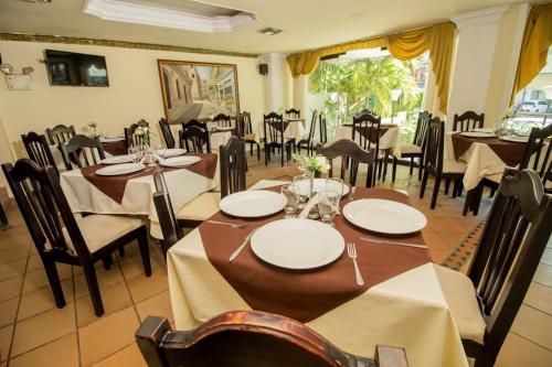 a dining room with tables and chairs in a restaurant at Hotel Caribe Plaza Barranquilla in Barranquilla