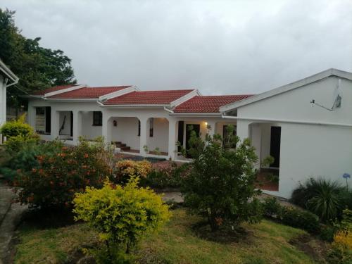 een wit huis met rood dak bij Ezamampondo Guest House in Koning Willemstad