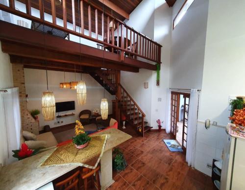 ein Wohnzimmer mit einem Tisch und einer Treppe in der Unterkunft Hospedaria Morada das Orquídeas in São Sebastião