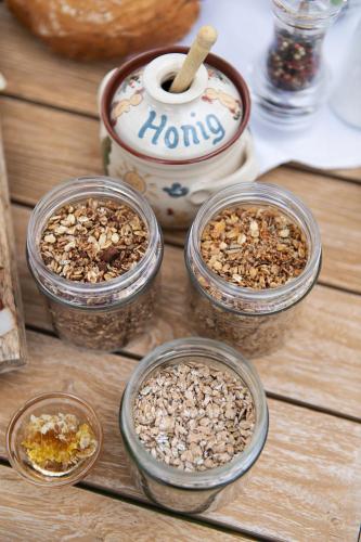 four glass jars filled with nuts on a wooden table at Hotel Schloss Lerchenhof in Hermagor