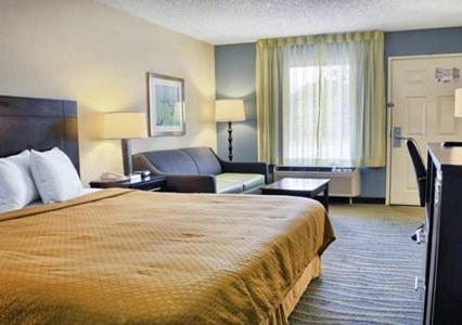 a hotel room with a large bed and a couch at Quality Inn Thornburg in Thornburg