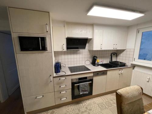 a kitchen with white cabinets and a stove top oven at Casa Veli Apartments in Offenburg