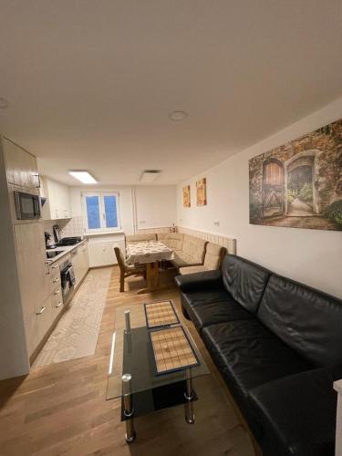 a living room with a black leather couch and a table at Casa Veli Apartments in Offenburg