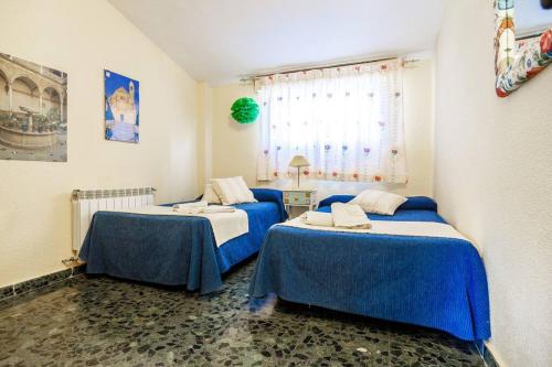 Dos camas en una habitación con azul y blanco. en La Veguilla Úbeda, en Úbeda