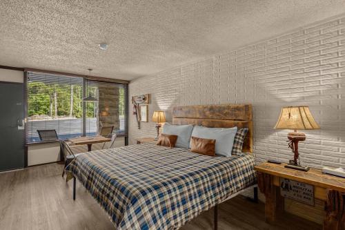 a bedroom with a bed and a desk and a window at Stonegate Lodge - Pool & Firepits Room #208 in Eureka Springs