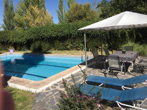 una mesa con sombrilla junto a la piscina en La Veguilla Úbeda, en Úbeda