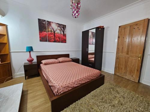Schlafzimmer mit einem Bett und einem Spiegel in der Unterkunft 1 Beautiful large room in Goodmayes