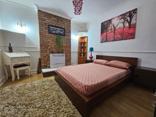Schlafzimmer mit einem Bett, einem Waschbecken und einem Schreibtisch in der Unterkunft 1 Beautiful large room in Goodmayes