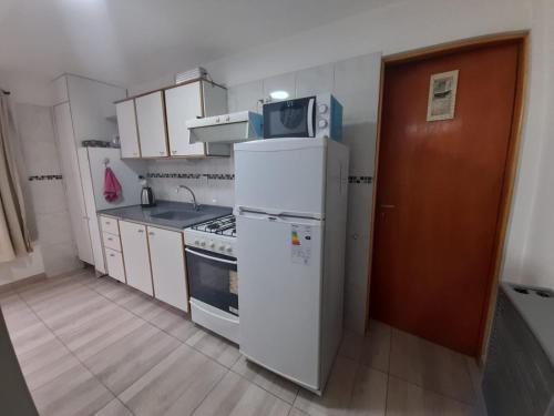 a small kitchen with a refrigerator and a microwave at Monseñor Fagnano 592 "5" in Ushuaia