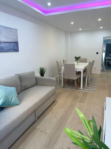a living room with a couch and a table with chairs at Lovely 2 bedroom apartment in South Lisbon in Barreiro