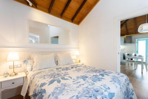 a bedroom with a blue and white bed and a dining room at casa mo Tenerife in Las Cruces