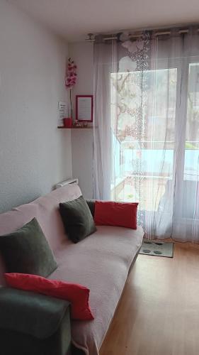 a couch in a living room with a window at 31 avenue GEORGES CLEMENCEAU in Le Mont-Dore